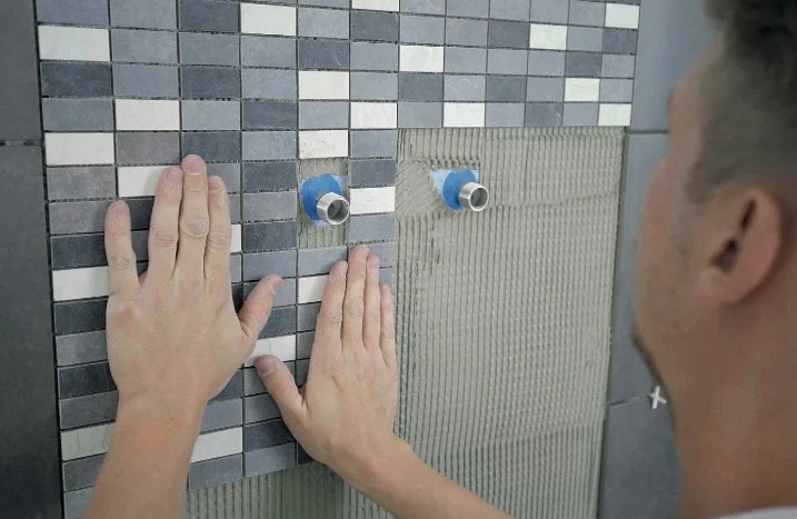 Person verlegt Mosaikfliesen